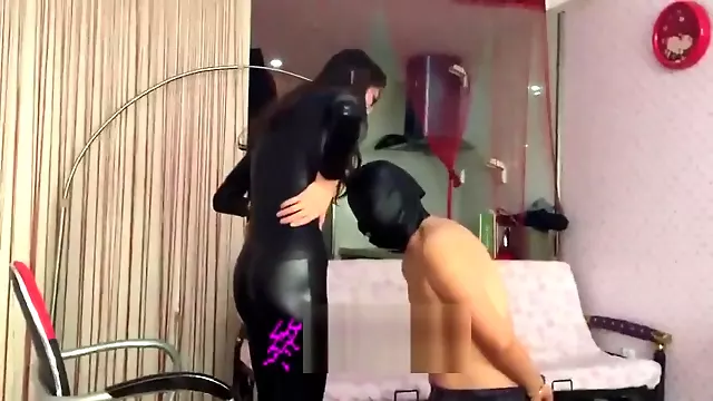 Chinese mistress in a bodysuit dominates her slave with Doc Martens